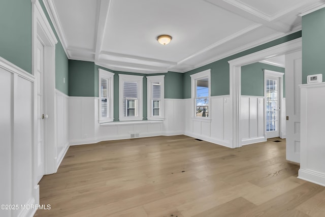 unfurnished room featuring coffered ceiling, crown molding, beamed ceiling, and light wood-type flooring