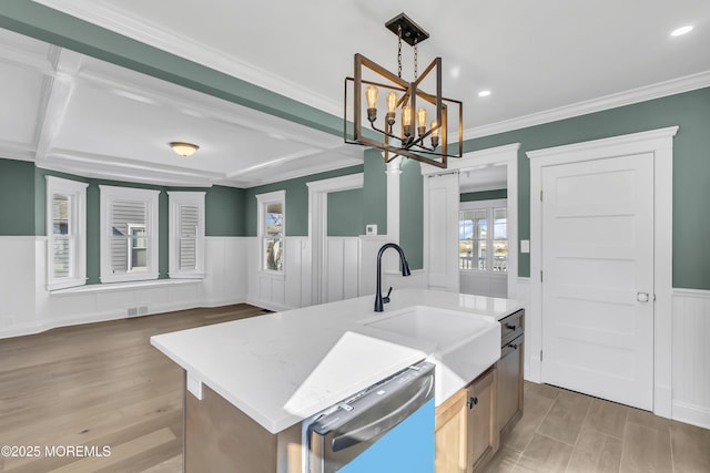 kitchen with pendant lighting, sink, crown molding, dishwasher, and a kitchen island with sink