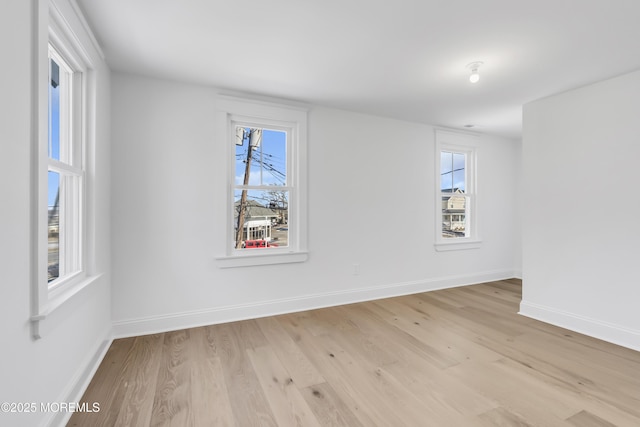 empty room featuring a healthy amount of sunlight and light hardwood / wood-style flooring