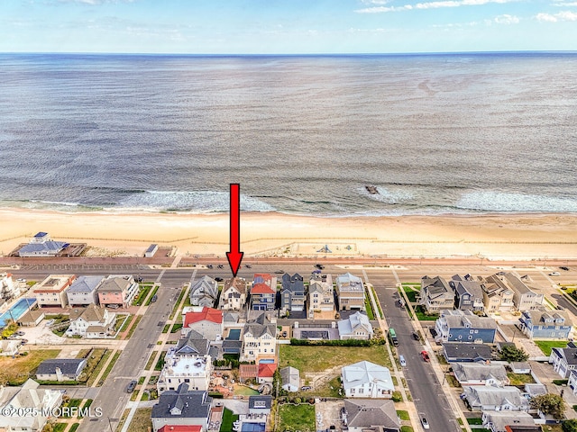 birds eye view of property with a water view and a beach view