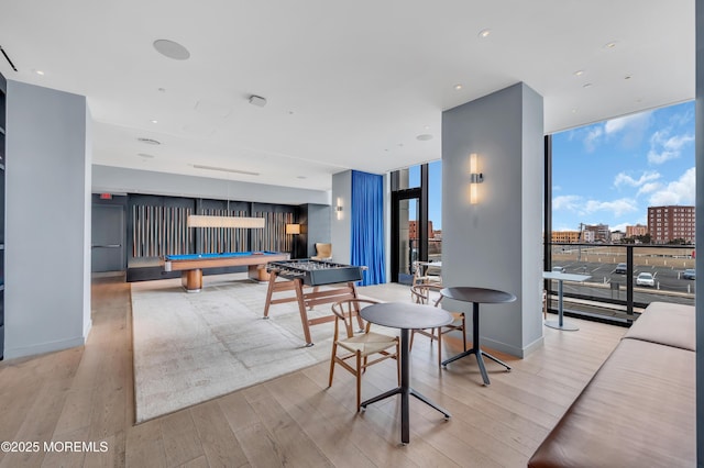 dining room with billiards, expansive windows, and light hardwood / wood-style floors