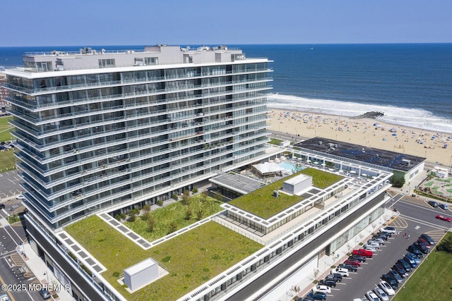 drone / aerial view featuring a water view and a view of the beach