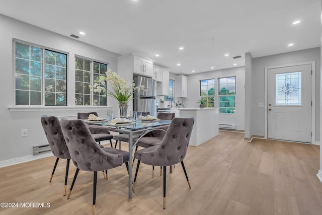 dining area with a baseboard radiator, sink, and light hardwood / wood-style floors