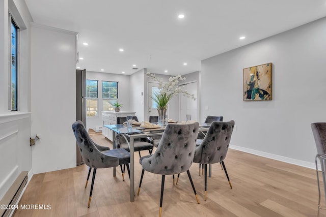 dining area featuring baseboard heating and light wood-type flooring