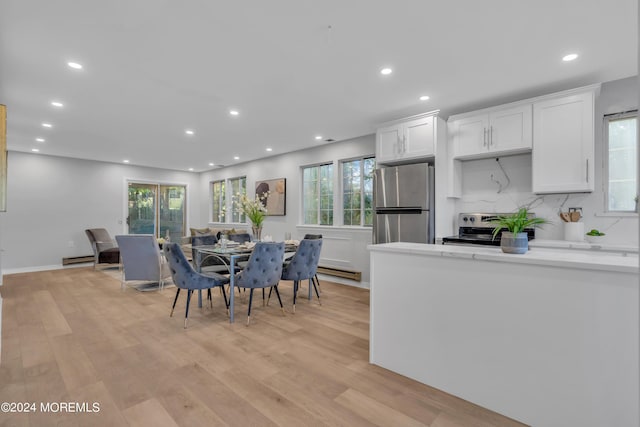 kitchen featuring white cabinetry, a wealth of natural light, stainless steel appliances, and light hardwood / wood-style floors