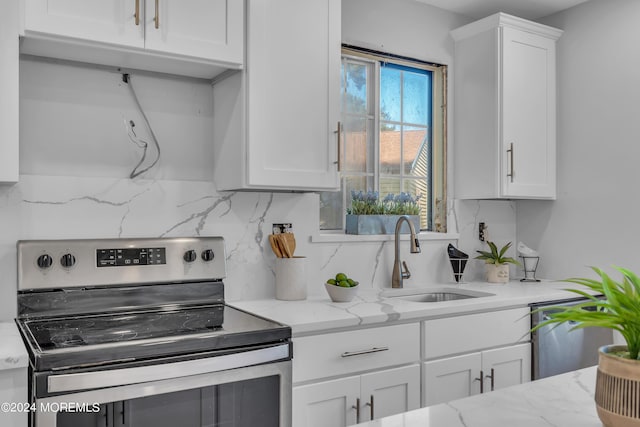 kitchen with white cabinetry, stainless steel appliances, sink, and tasteful backsplash