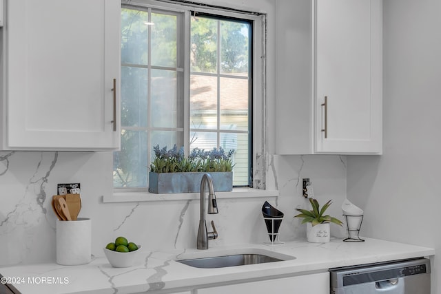 kitchen featuring white cabinetry, sink, light stone countertops, and dishwasher