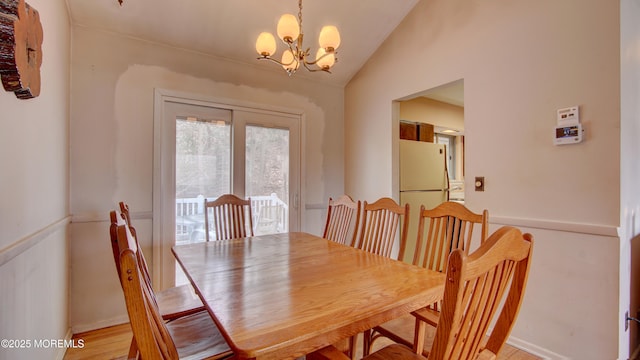 dining space with lofted ceiling and an inviting chandelier