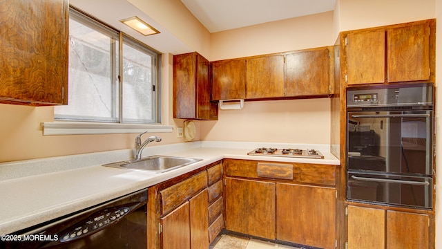 kitchen featuring white gas stovetop, black dishwasher, light countertops, a sink, and a warming drawer