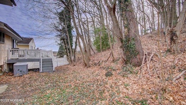 view of yard with central AC and a deck