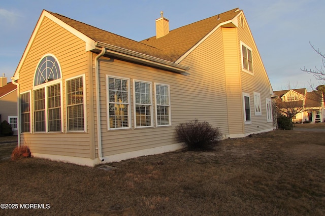 view of home's exterior with a yard and a chimney