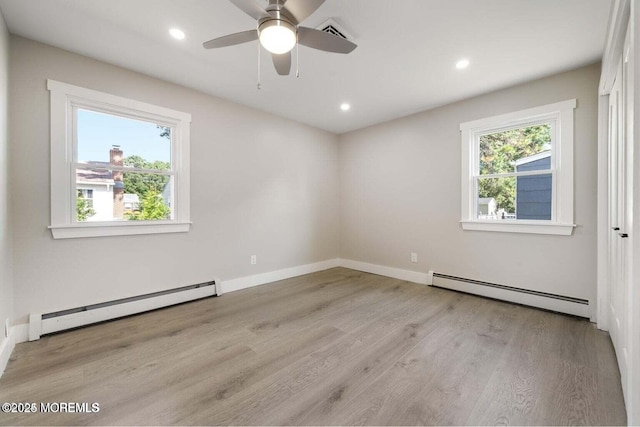 unfurnished room featuring light hardwood / wood-style floors, ceiling fan, and baseboard heating