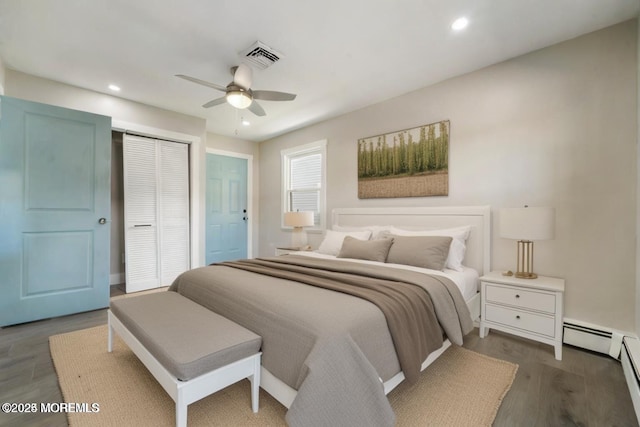 bedroom featuring dark wood-type flooring, a baseboard radiator, a closet, and ceiling fan