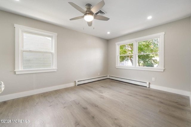 unfurnished room featuring a baseboard heating unit, light hardwood / wood-style floors, and ceiling fan