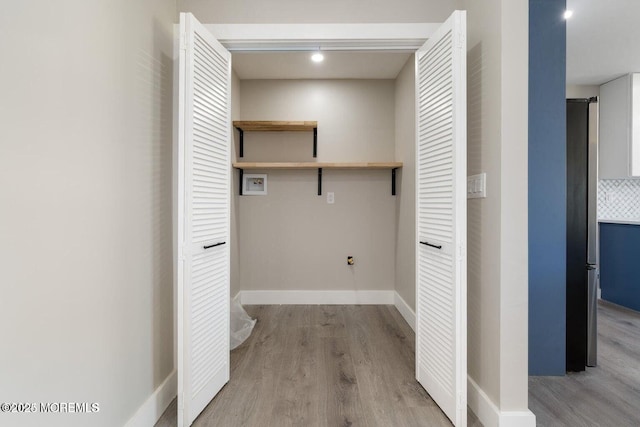 washroom featuring hookup for a washing machine and light wood-type flooring