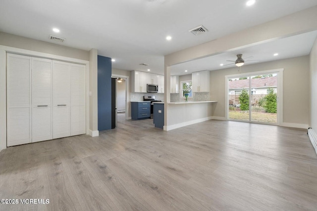 unfurnished living room featuring ceiling fan and light hardwood / wood-style floors