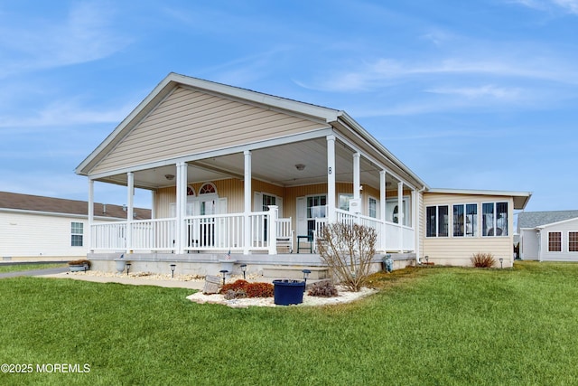 rear view of property featuring a yard and a porch