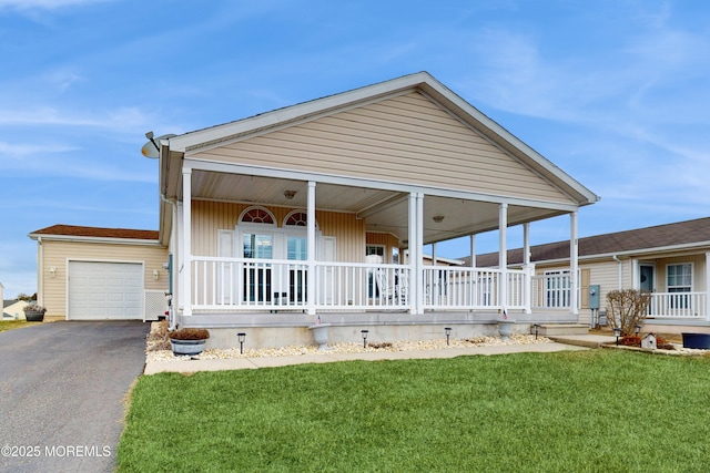 view of front facade with a garage, aphalt driveway, a porch, and a front yard