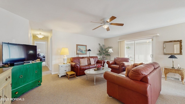 living area with light carpet, ceiling fan, and baseboards