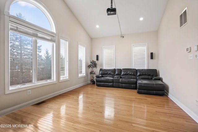 living room with light wood-style flooring, visible vents, and baseboards