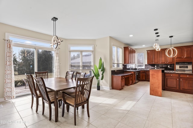 dining space featuring recessed lighting, a notable chandelier, baseboards, and light tile patterned floors