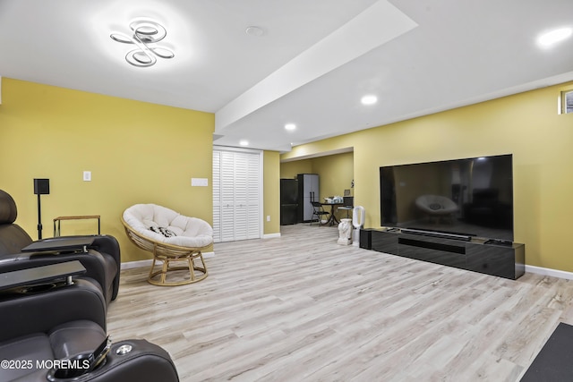 living room with baseboards, wood finished floors, and recessed lighting