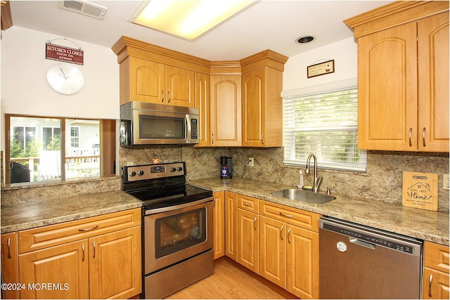 kitchen featuring decorative backsplash, visible vents, stainless steel appliances, and a sink