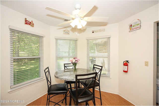 dining area with wood finished floors, a ceiling fan, and baseboards