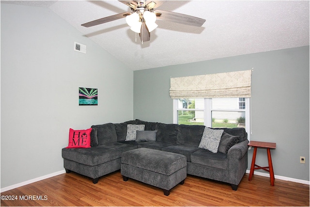 living area with lofted ceiling, visible vents, baseboards, and wood finished floors