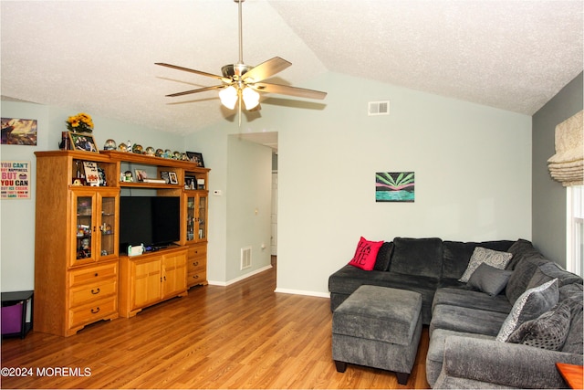 living area featuring visible vents, lofted ceiling, ceiling fan, a textured ceiling, and light wood-style floors