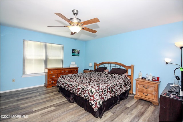 bedroom featuring ceiling fan, baseboards, and wood finished floors