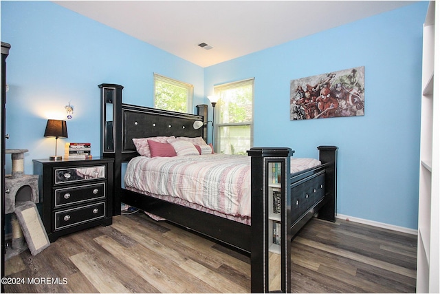 bedroom with dark wood-style floors, baseboards, and visible vents