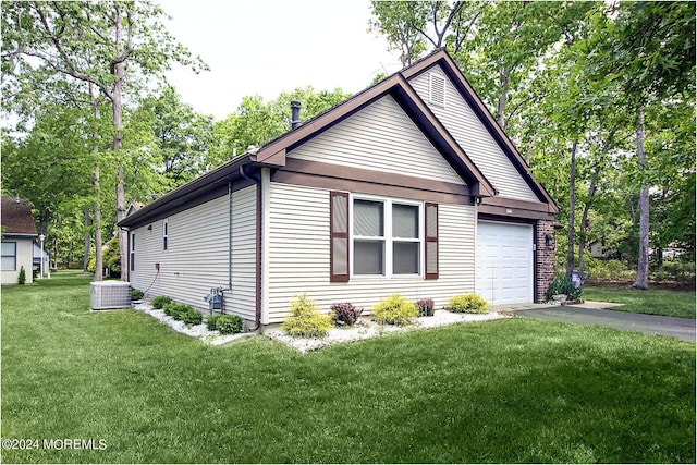 view of home's exterior featuring a yard, driveway, an attached garage, and central AC unit