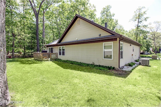 back of property with a deck, a yard, and central AC unit