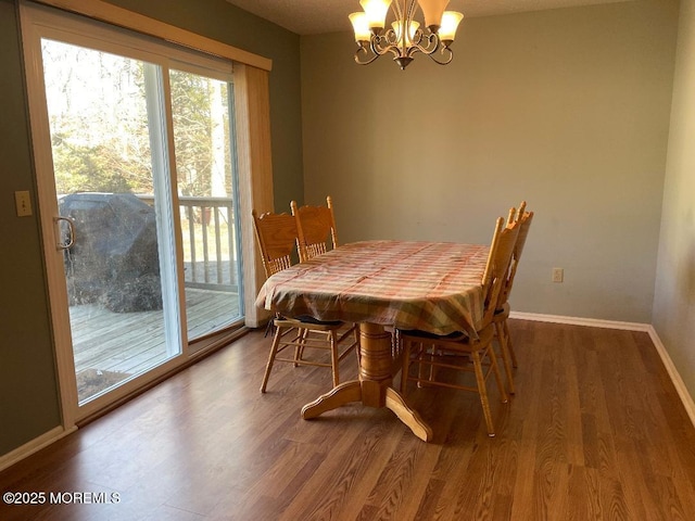 dining room with baseboards, a chandelier, and wood finished floors