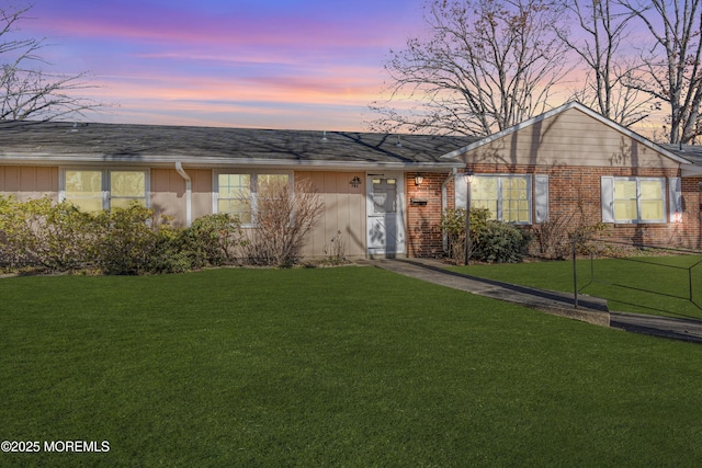 single story home featuring brick siding and a lawn