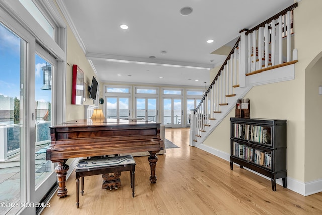 sitting room featuring baseboards, wood finished floors, stairs, crown molding, and recessed lighting