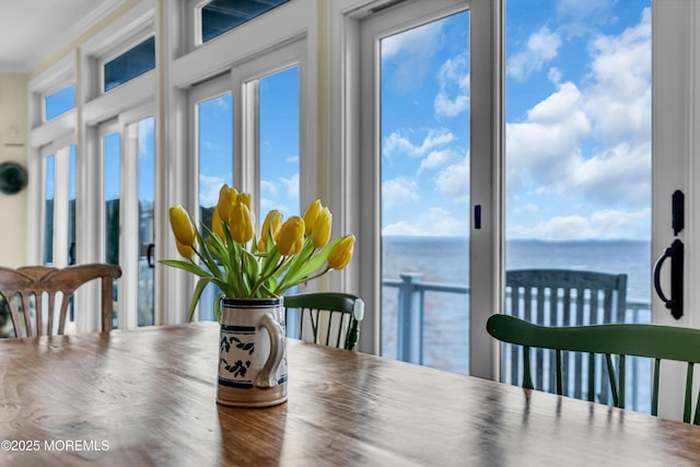 dining room with a water view and crown molding