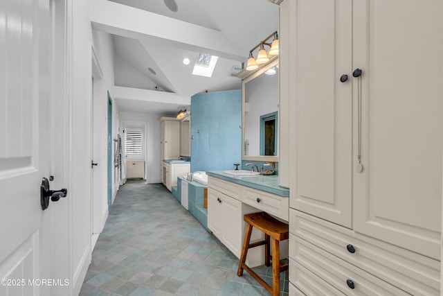 bathroom with lofted ceiling with skylight, recessed lighting, and vanity