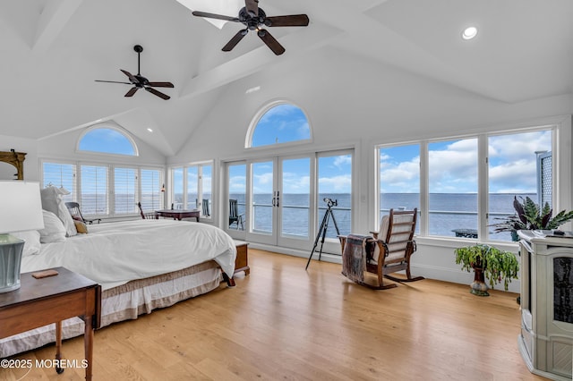 bedroom with access to exterior, french doors, light wood finished floors, a water view, and high vaulted ceiling