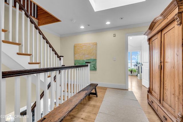 interior space featuring light wood finished floors, baseboards, crown molding, and recessed lighting