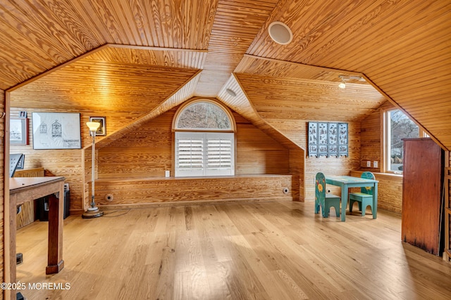 additional living space with lofted ceiling, wooden ceiling, wooden walls, and wood finished floors