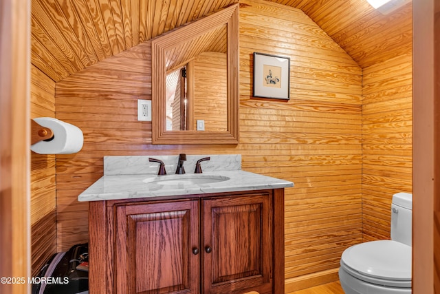 bathroom with lofted ceiling, vanity, and toilet