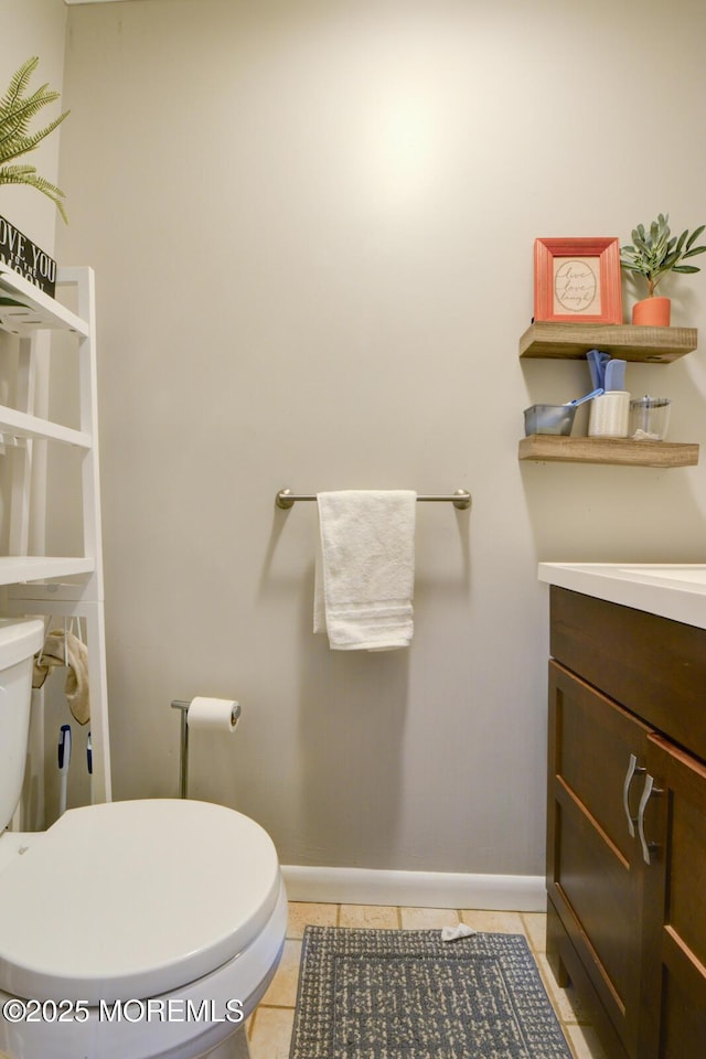 bathroom with tile patterned flooring, vanity, and toilet