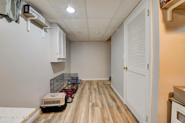 hall with a drop ceiling and light hardwood / wood-style floors