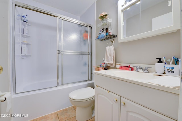 full bathroom featuring bath / shower combo with glass door, vanity, tile patterned floors, and toilet