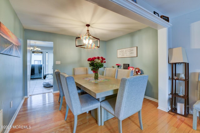 dining space featuring an inviting chandelier and light hardwood / wood-style floors