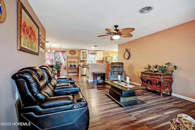 living room with hardwood / wood-style flooring and ceiling fan with notable chandelier