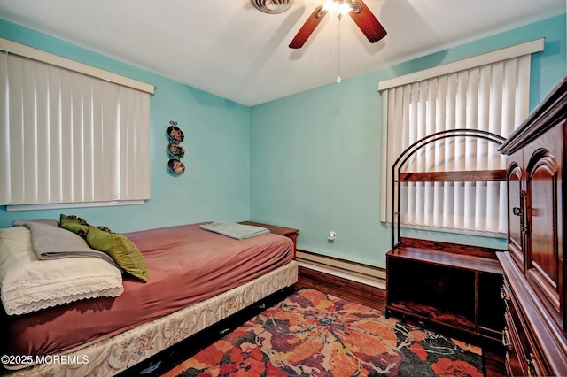 bedroom featuring ceiling fan, hardwood / wood-style floors, and baseboard heating