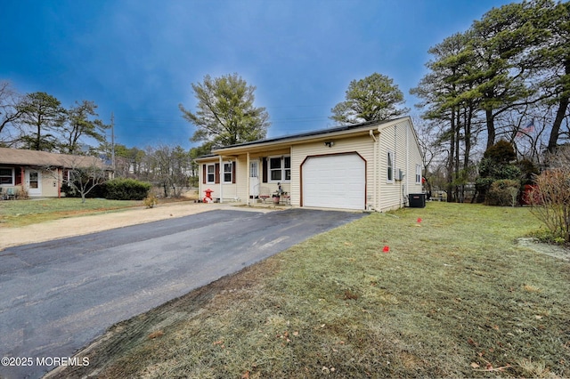 view of front facade with cooling unit, a garage, and a front yard